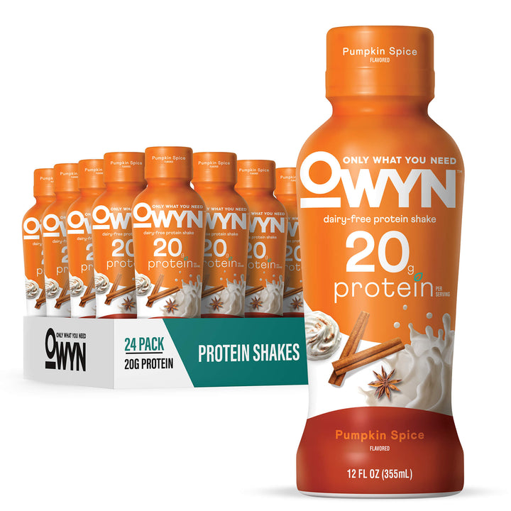A 24-pack display of OWYN Pumpkin Spice flavored protein shakes with one large bottle in the foreground, showing orange labels with white and teal branding on a clean white background.